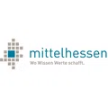 Logo von Mittelhessen mit dem Slogan 'Wo Wissen Werte schafft' und einem pixelartigen Quadratdesign links, welches Hessen in Grau und Mittelhessen in Blau darstellt.
