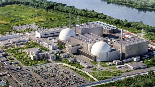 Luftaufnahme eines großen Industriekomplexes mit zwei kugelförmigen Reaktorgebäuden neben einem Fluss