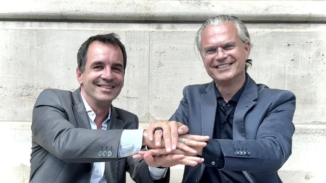 Zwei Männer in Anzügen, Andreas Lukic und Felix Hamann von den Business Angels Mittelhessen, stehen vor einer Wand und legen ihre Hände übereinander