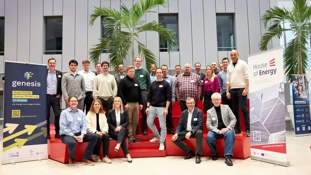 Gruppenfoto von Personen auf roten Stufen vor einer modernen Fassade mit zwei Roll-ups zu Green-Energy-Startups und House of Energy