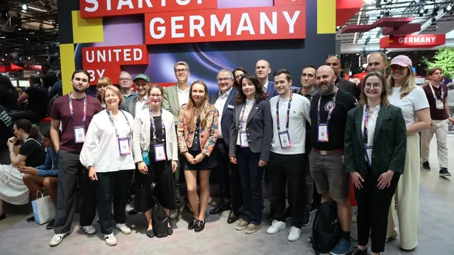Gruppe von Menschen vor einem Messestand mit dem Schriftzug 'STARTUP GERMANY'