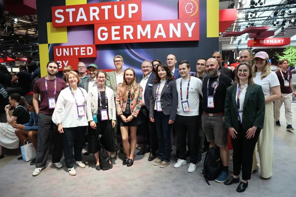 Gruppe von Menschen vor einem Messestand mit dem Schriftzug 'STARTUP GERMANY'