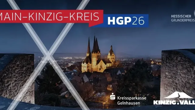 Nachtaufnahme einer Stadt mit einer beleuchteten Kirche und zwei hohen Türmen, im Vordergrund zwei beleuchtete, sich kreuzende Stahlträger, darüber rote und blaue Banner mit den Schriftzügen 'MAIN-KINZIG-KREIS' und 'HGP26' sowie Logos von 'Kreissparkasse