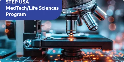 Mikroskop auf einem Laborarbeitsplatz mit Text 'STEP USA MedTech/Life Sciences Program' in blauem Feld