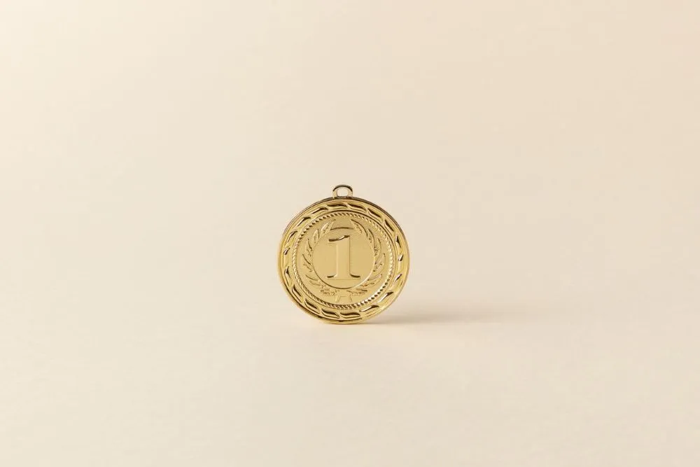 Goldene Medaille mit der Zahl 1 und Lorbeerkranz auf hellem Hintergrund