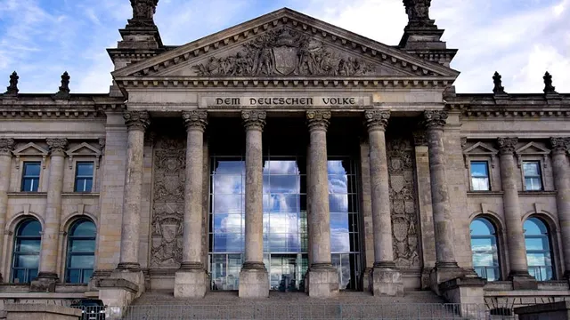Fassade des Reichstagsgebäudes in Berlin mit der Inschrift 'Dem Deutschen Volke' über sechs Säulen