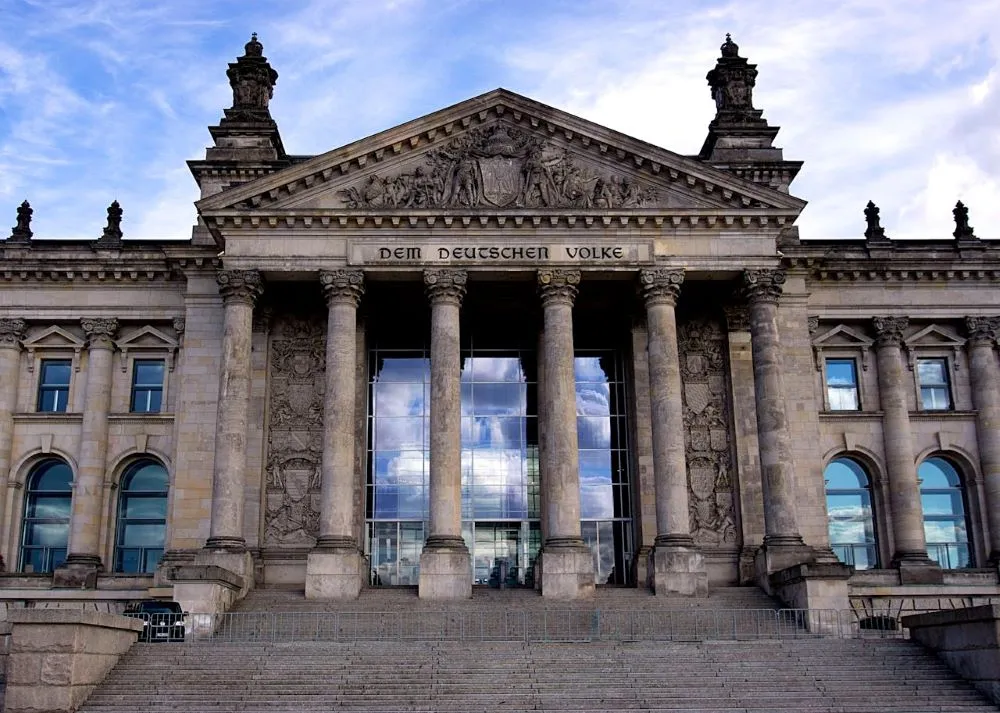 Fassade des Reichstagsgebäudes in Berlin mit der Inschrift 'Dem Deutschen Volke' über sechs Säulen