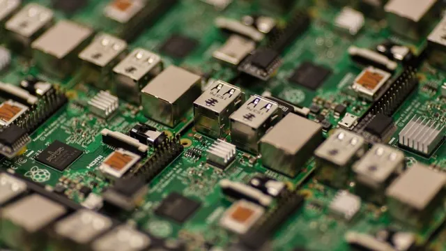 Nahaufnahme einer grünen Leiterplatte mit verschiedenen elektronischen Bauteilen und USB-Anschlüssen