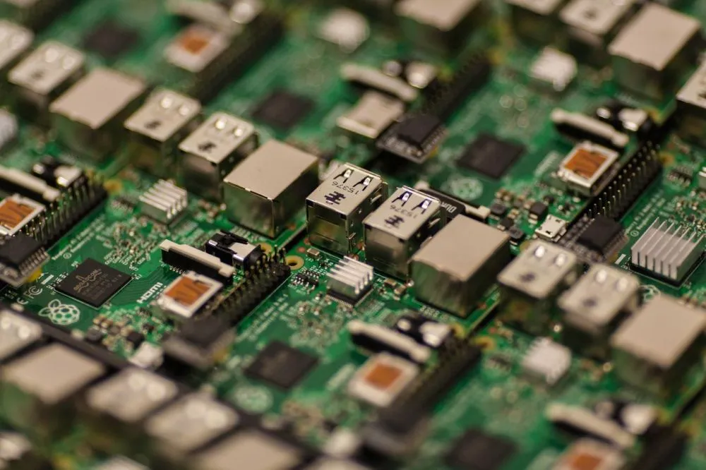 Nahaufnahme einer grünen Leiterplatte mit verschiedenen elektronischen Bauteilen und USB-Anschlüssen