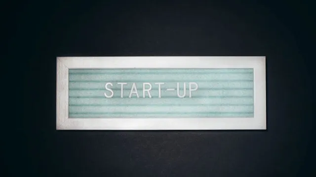 Leuchtschild mit dem Schriftzug 'START-UP' auf schwarzem Hintergrund
