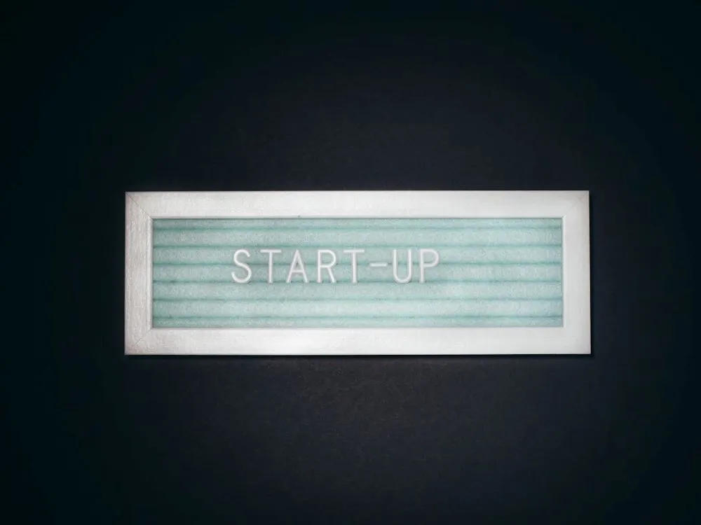 Leuchtschild mit dem Schriftzug 'START-UP' auf schwarzem Hintergrund