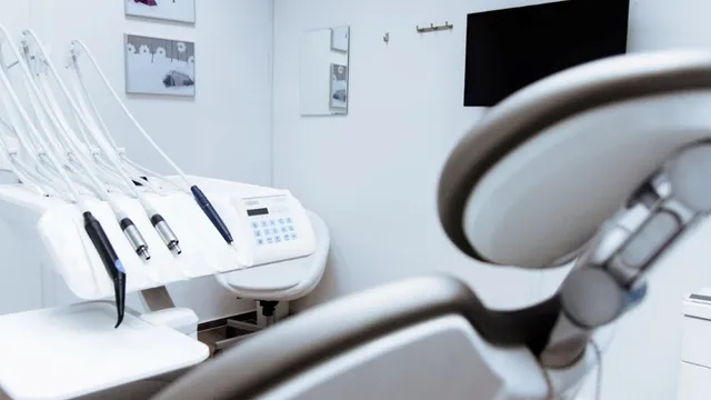 Zahnbehandlungsraum mit Zahnarztstuhl, zahnärztlichen Instrumenten und Monitor an der Wand